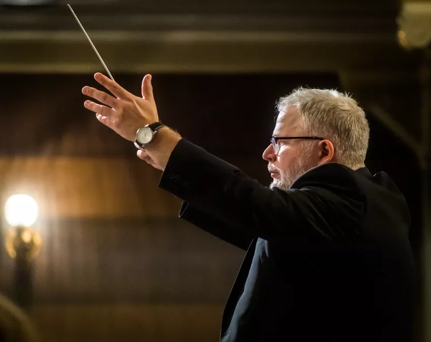 Dirigenten Patrik Andersson dirigerar. Foto. 